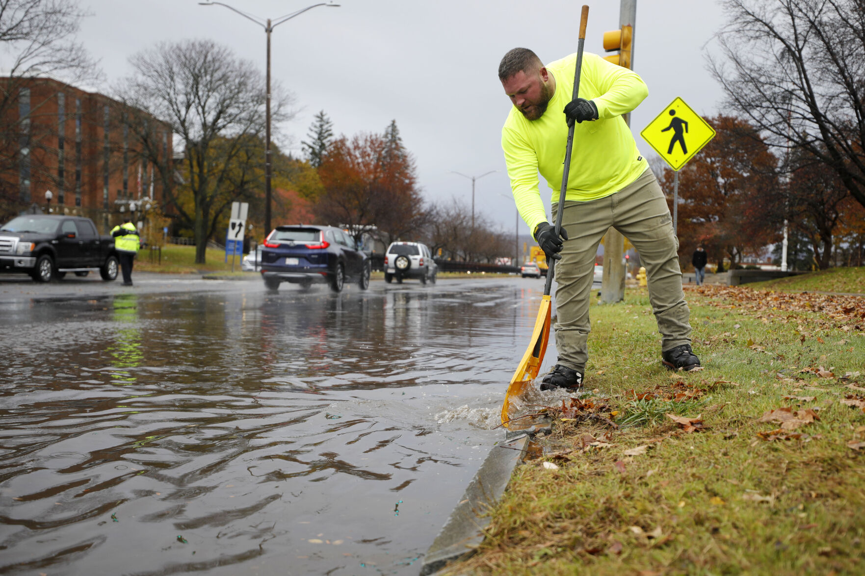 jim shea clearing leaves from flooded storm drain
